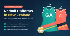 Illustration of two custom netball dresses on hangers, a teal dress marked GA and a coral dress marked C, next to a netball, with the heading "Netball Uniforms in New Zealand" and tips on stock versus sublimated kits, fabric, fit, kit rules and bulk team orders.